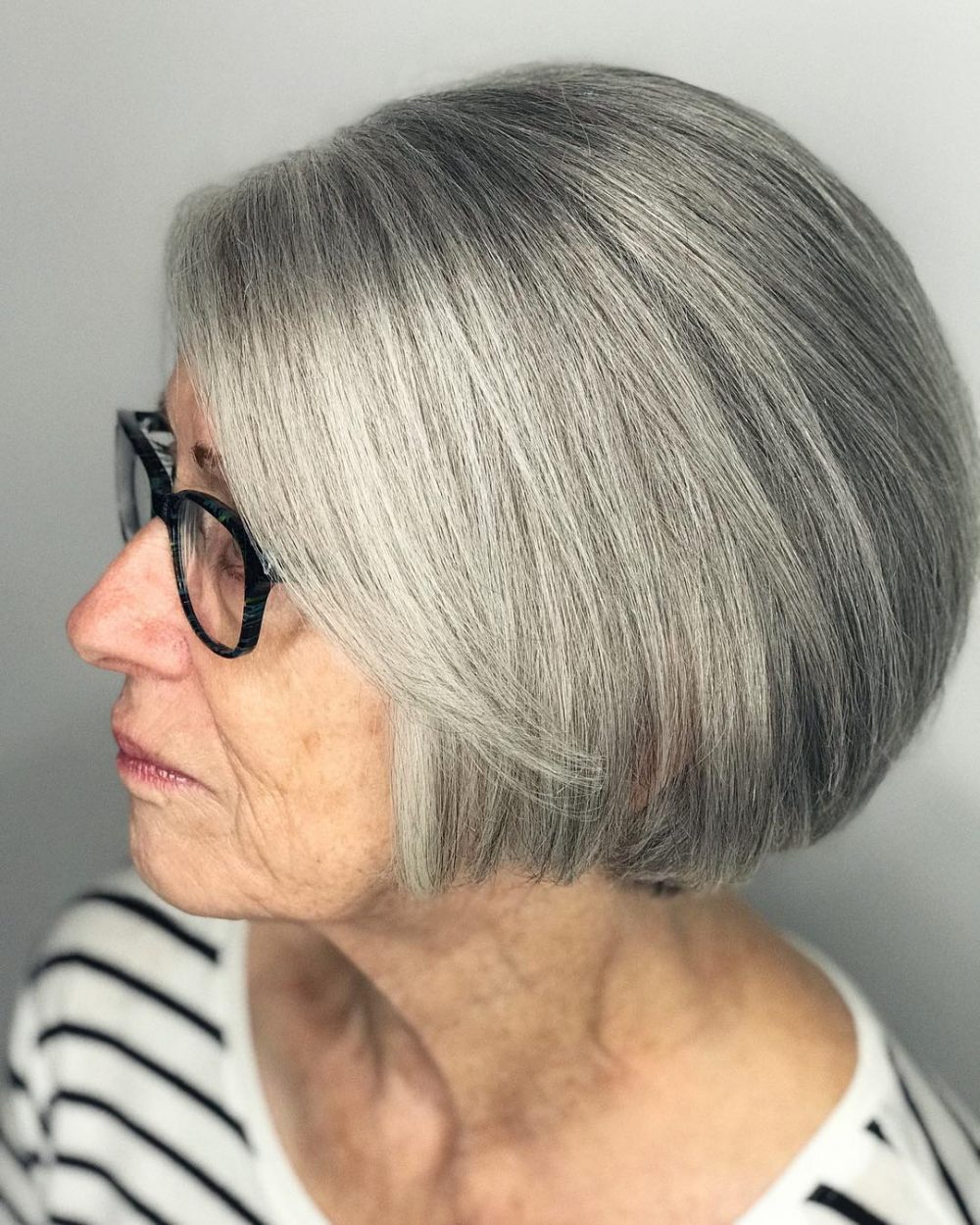 Penteado cinza curto para mulheres com mais de 60 anos com óculos
