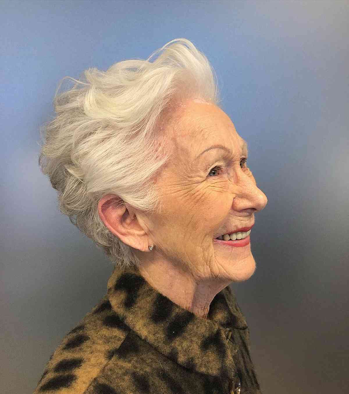 Corte de duende curto nervoso com cabelo branco para uma mulher de 60 anos
